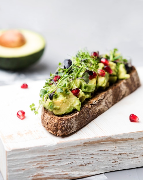 Fetta di pane con pasta di avocado e primo piano di verdure