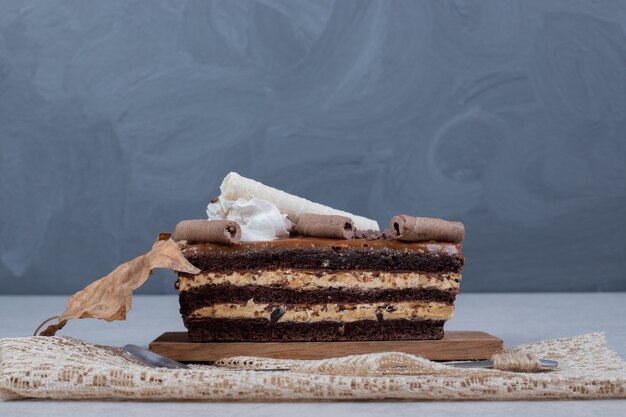 Fetta di torta al cioccolato con foglia sul tavolo di marmo. Foto di alta qualità