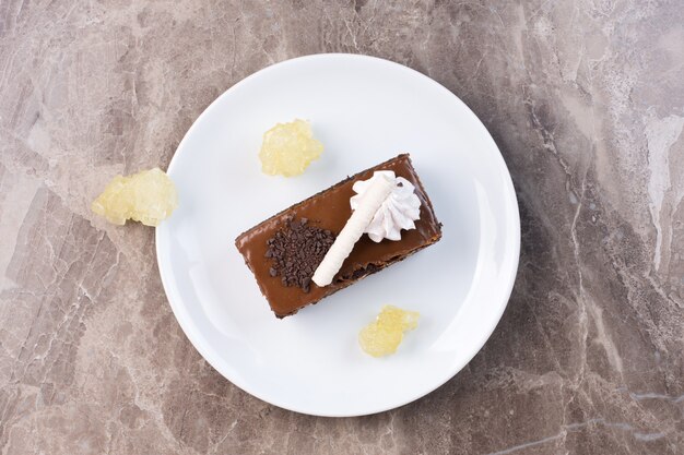 Fetta di torta al cioccolato sulla zolla bianca.