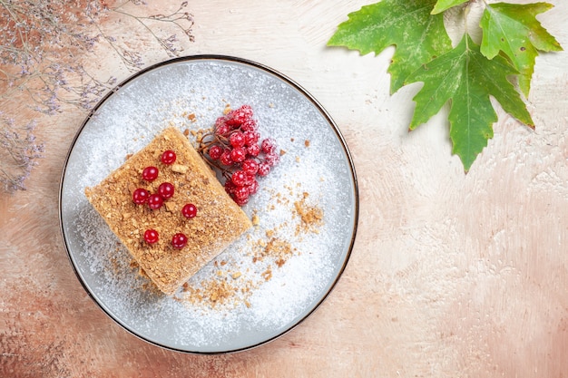 Fetta di torta squisita vista dall'alto con bacche rosse sulla luce