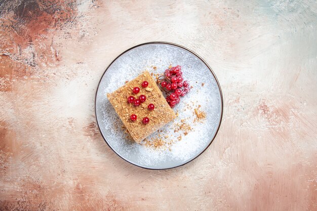 Fetta di torta squisita vista dall'alto con bacche rosse sulla luce