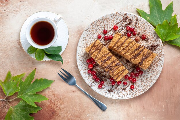 Fetta di torta squisita vista dall'alto con tè e frutti di bosco in luce