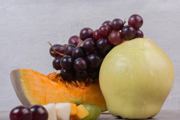 Fetta di zucca con pera e uva sul tavolo bianco.