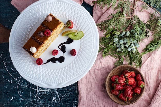 Fetta quadrata di torta al caramello con fragole, vista dall'alto.