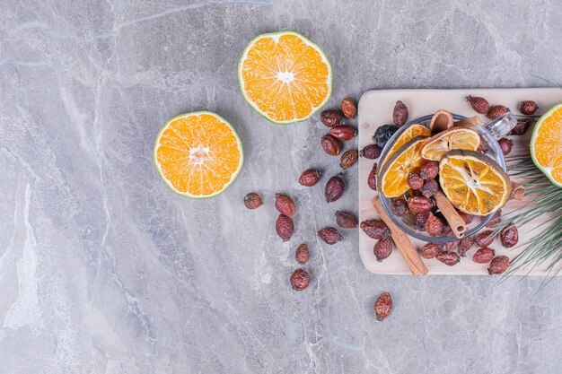 Fette d'arancia con fianchi asciutti e cinnamons su un piatto grigio