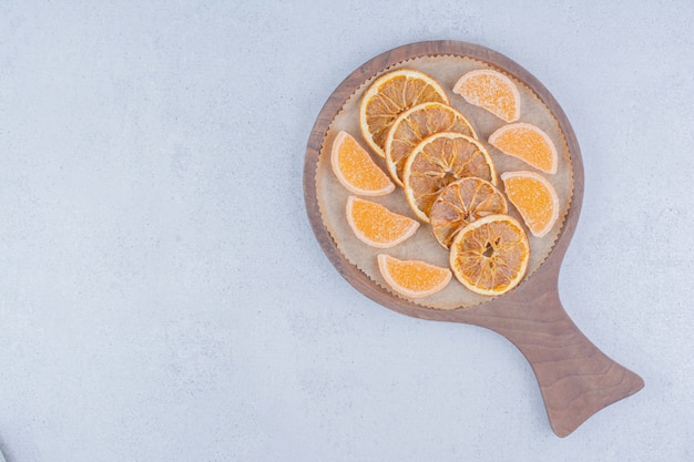 Fette d'arancia essiccate e marmellate su tavola di legno.