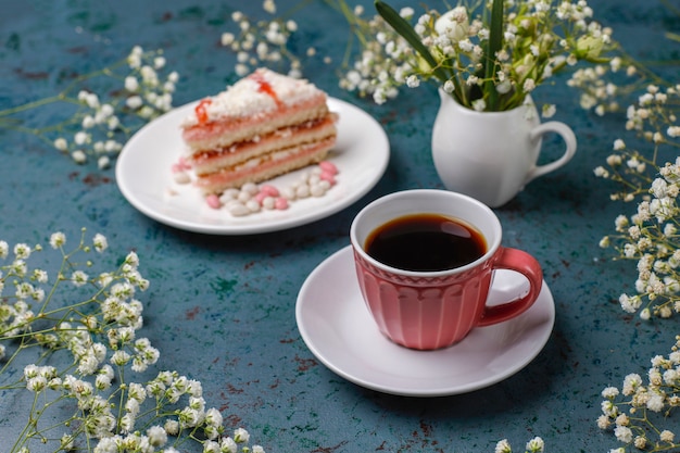 Fette del pan di Spagna di Victoria con una tazza di caffè su luce