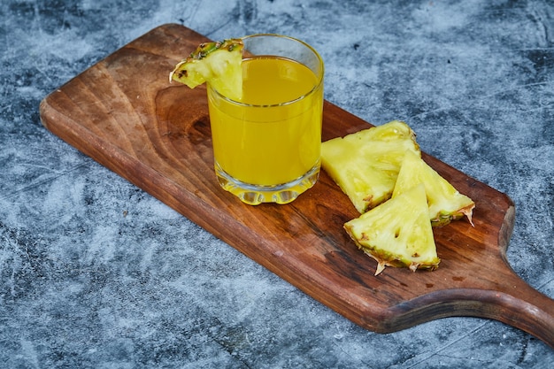 Fette di ananas e succo di ananas su tavola di legno