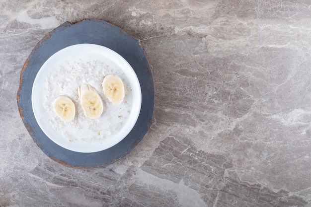 Fette di banana su un piatto di riso, sullo sfondo di marmo.