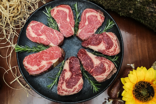 Fette di carne cruda poste in padella con erbe aromatiche