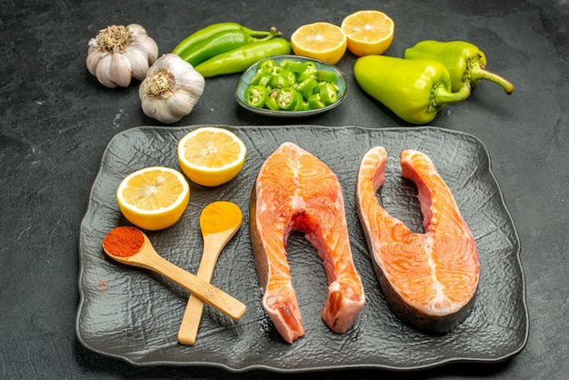 Fette di carne fritte vista frontale con peperoni aglio e limone su sfondo scuro piatto di colore piatto insalata di costolette cibo