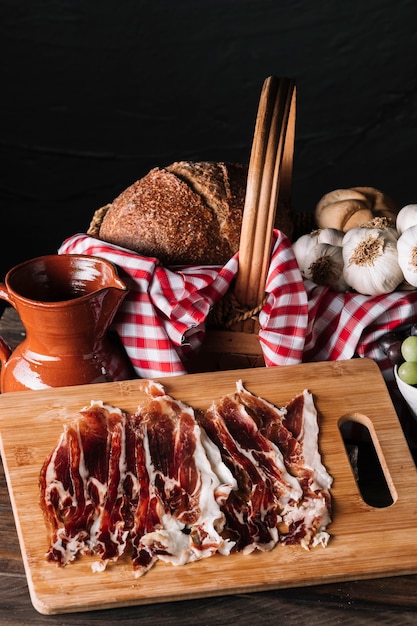 Fette di carne vicino a brocca e cibo