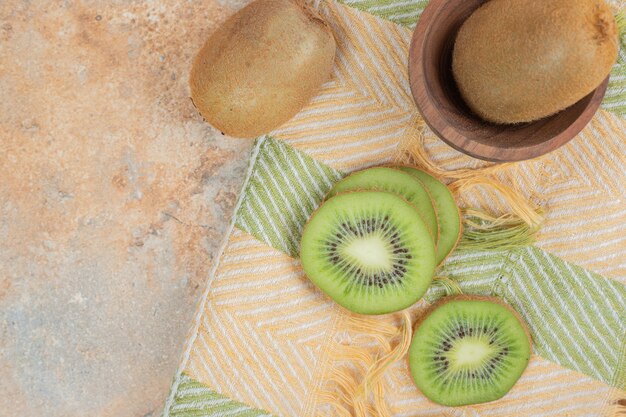 Fette di kiwi fresco sulla tovaglia colorata.