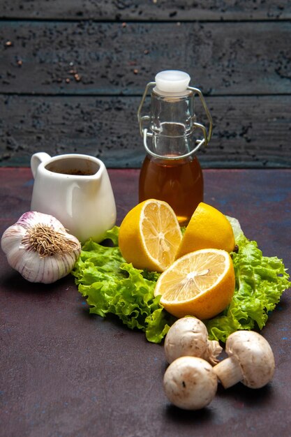 Fette di limone fresche di vista frontale con insalata verde e funghi su spazio scuro