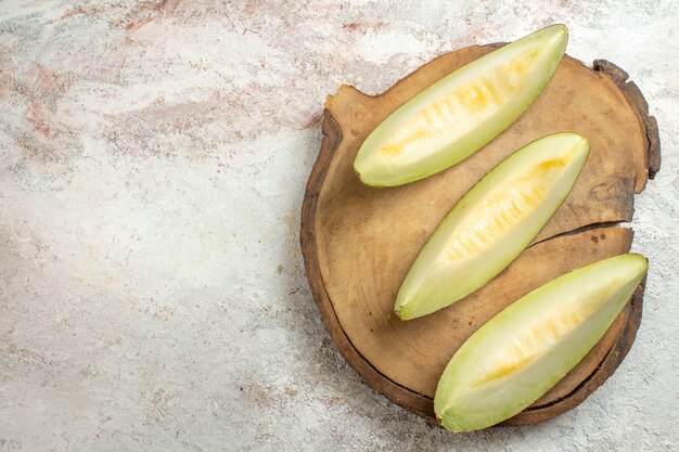 Fette di melone su piatto di legno sul lato destro del marmo