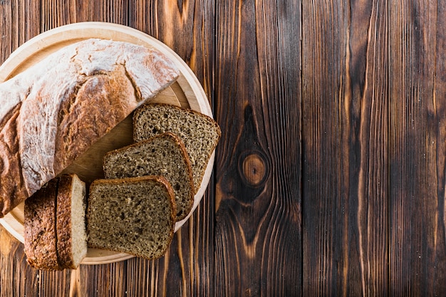 Fette di pane al forno sul piatto sopra i precedenti di legno