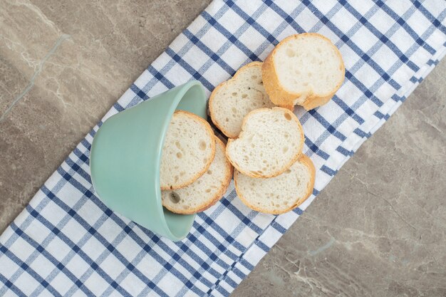 Fette di pane baguette dalla ciotola sulla tovaglia. Foto di alta qualità