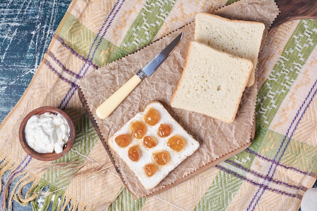 Fette di pane bianco con panna acida e confettura.