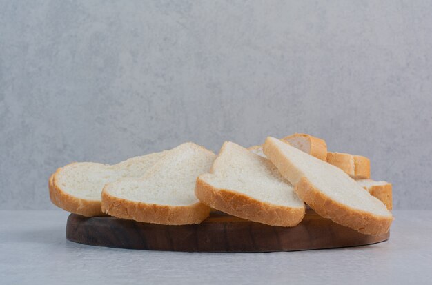 Fette di pane bianco fresco su sfondo marmo.