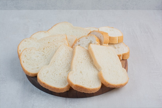 Fette di pane bianco fresco su sfondo marmo.