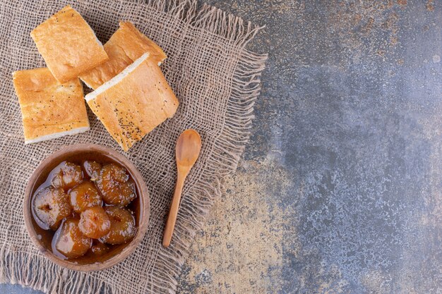 Fette di pane con una tazza di confettura di fichi