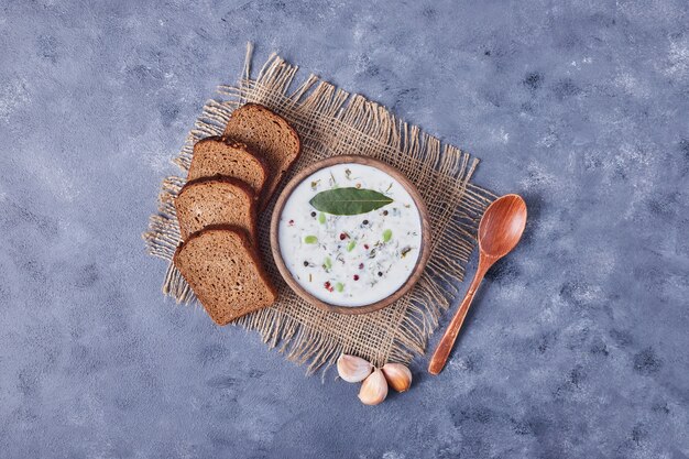 Fette di pane con una tazza di zuppa di yogurt e garlics, vista dall'alto.