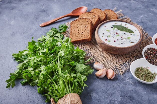 Fette di pane con una tazza di zuppa di yogurt.