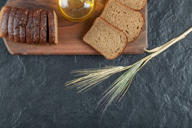 Fette di pane integrale con grano su tavola di legno.