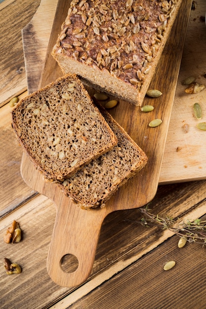 Fette di pane integrale di grano intero con semi di girasole sul tagliere