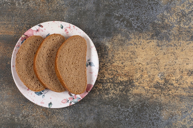 Fette di pane nero fatto in casa sul piatto colorato