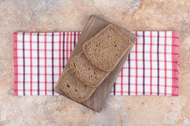 Fette di pane nero su tavola di legno con tovaglia