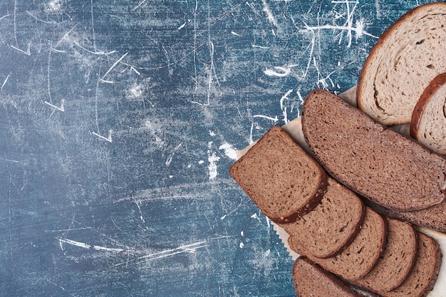 Fette di pane scuro su tavola di legno.