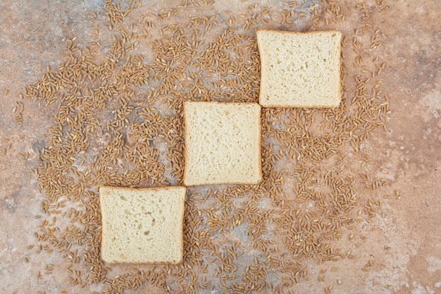 Fette di pane tostato bianco con orzo su fondo di marmo