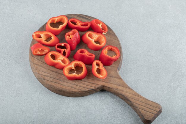 Fette di peperoni rossi dolci su una tavola di legno.