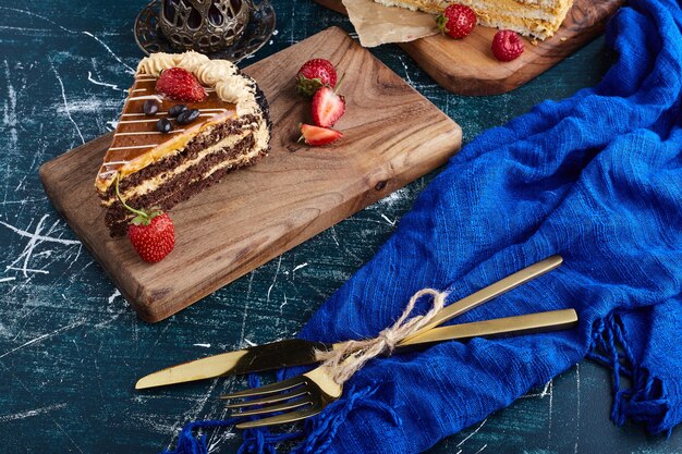 Fette di torta al caramello al cioccolato su una tavola di legno.