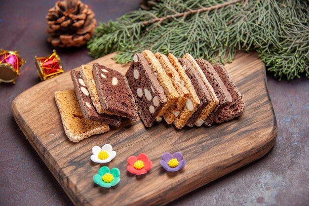 Fette di torta deliziose vista frontale con noci e cacao nello spazio buio