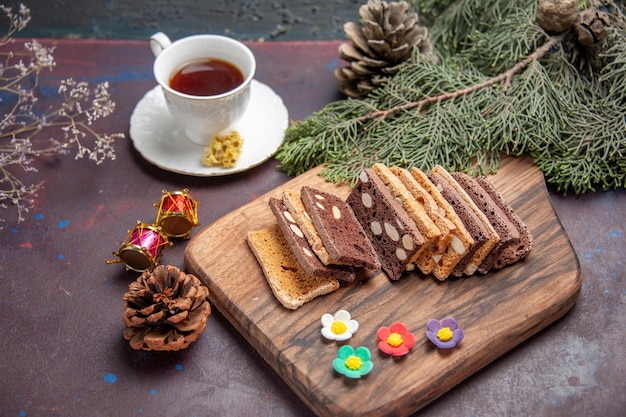 Fette di torta deliziose vista frontale con noci e cacao nello spazio buio