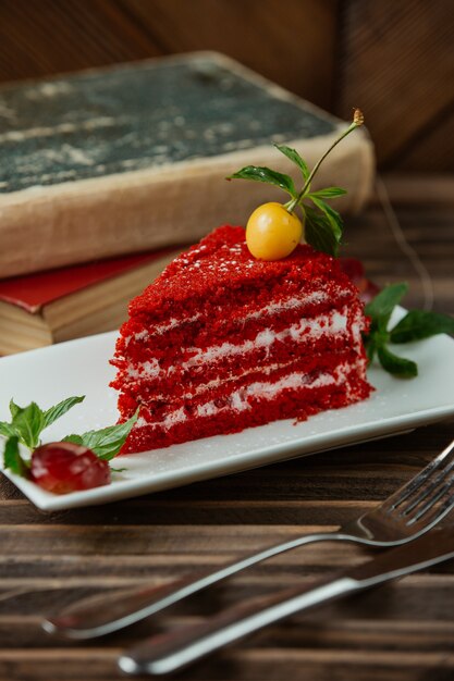 Fette di torta di velluto rosso con ciliegia yellof nella parte superiore e foglie di menta
