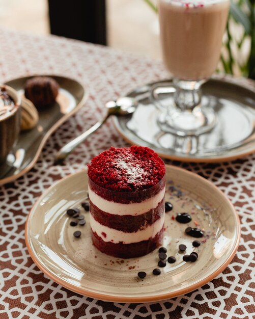 Fette di torta di velluto rosso con gocce di cioccolato all'interno del piatto marrone.