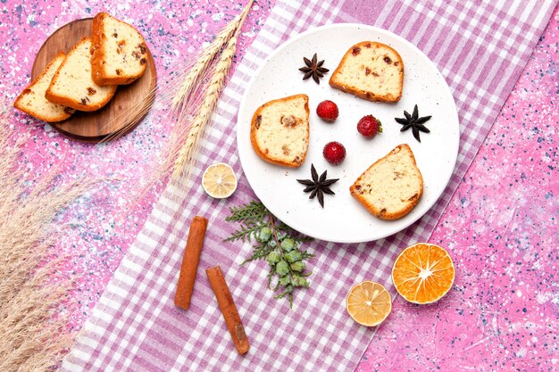 Fette di torta vista dall'alto con fragole e cannella sullo sfondo rosa torta cuocere biscotti dolci biscotti color zucchero torta