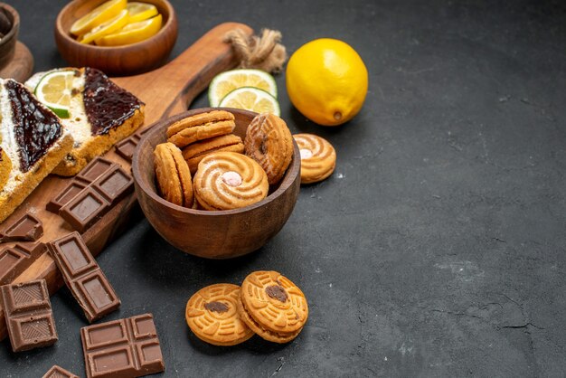 Fette di torta vista frontale con biscotti e cioccolato su sfondo scuro torta dessert torta dolce