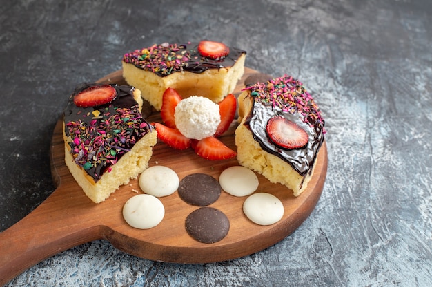 Fette di torta vista frontale con biscotti su sfondo scuro-chiaro