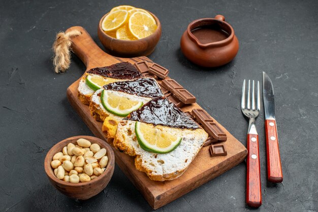 Fette di torta vista frontale con cioccolato su sfondo scuro