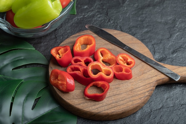 Fette fresche del peperone rosso sul tagliere di legno.