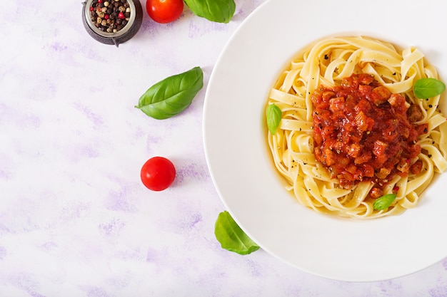 Fettuccine alla bolognese con salsa di pomodoro in ciotola bianca. Disteso. Vista dall'alto