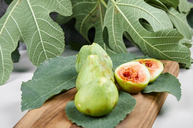 Fichi con semi rossi su un piatto di legno.