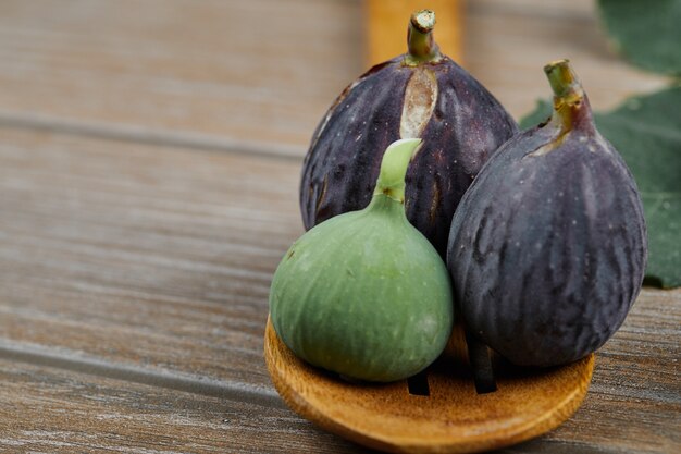 Fichi maturi sul cucchiaio di legno, primi piani.