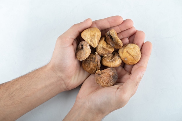 Fichi saporiti secchi intorno al piatto di legno.