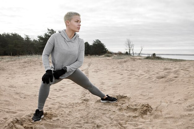 Fiducioso attraente giovane atleta femminile con corti capelli biondi