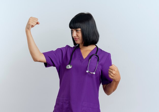 Fiducioso giovane dottoressa bruna in uniforme con stetoscopio